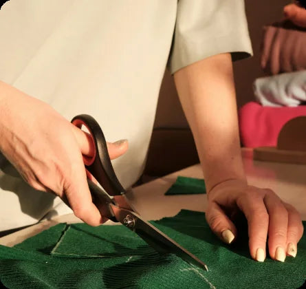 Experienced tailor hand-cutting fabric for a custom slipcover